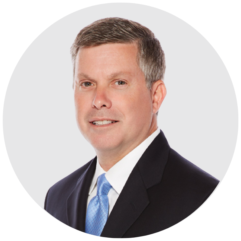 leadership team member headshot of a man with brown hair, brown eyes, wearing a suit and tie smiling into the camera