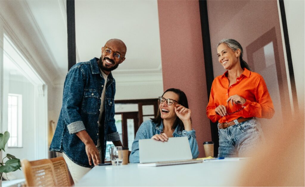 coworkers around each other looking out laughing