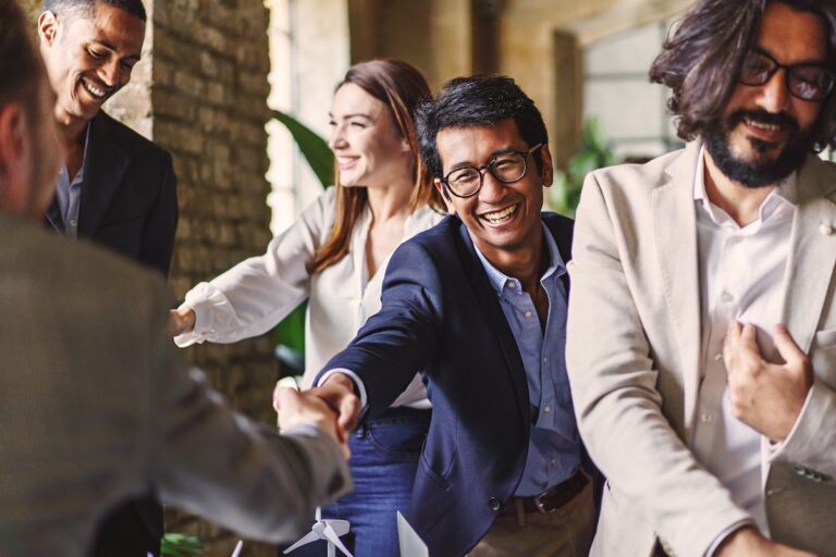 professionals celebrating with a handshake at a corporate event.