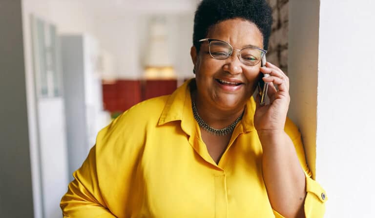 older woman smiling while using her phone