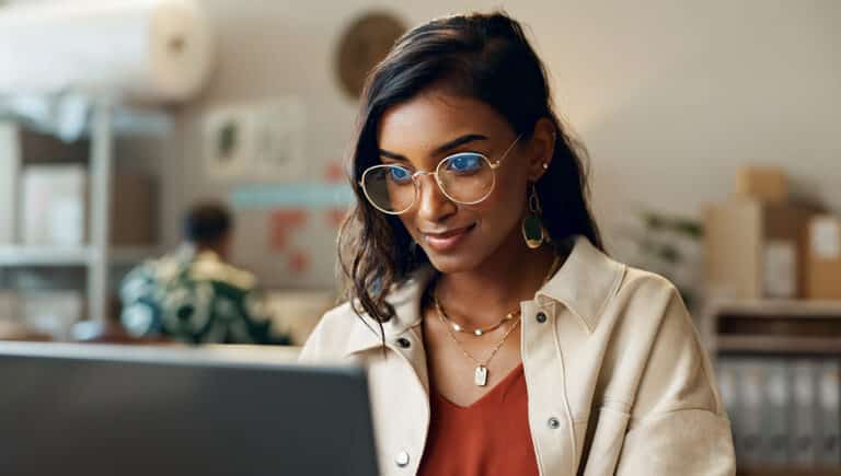 smiling and optimistic woman using her laptop