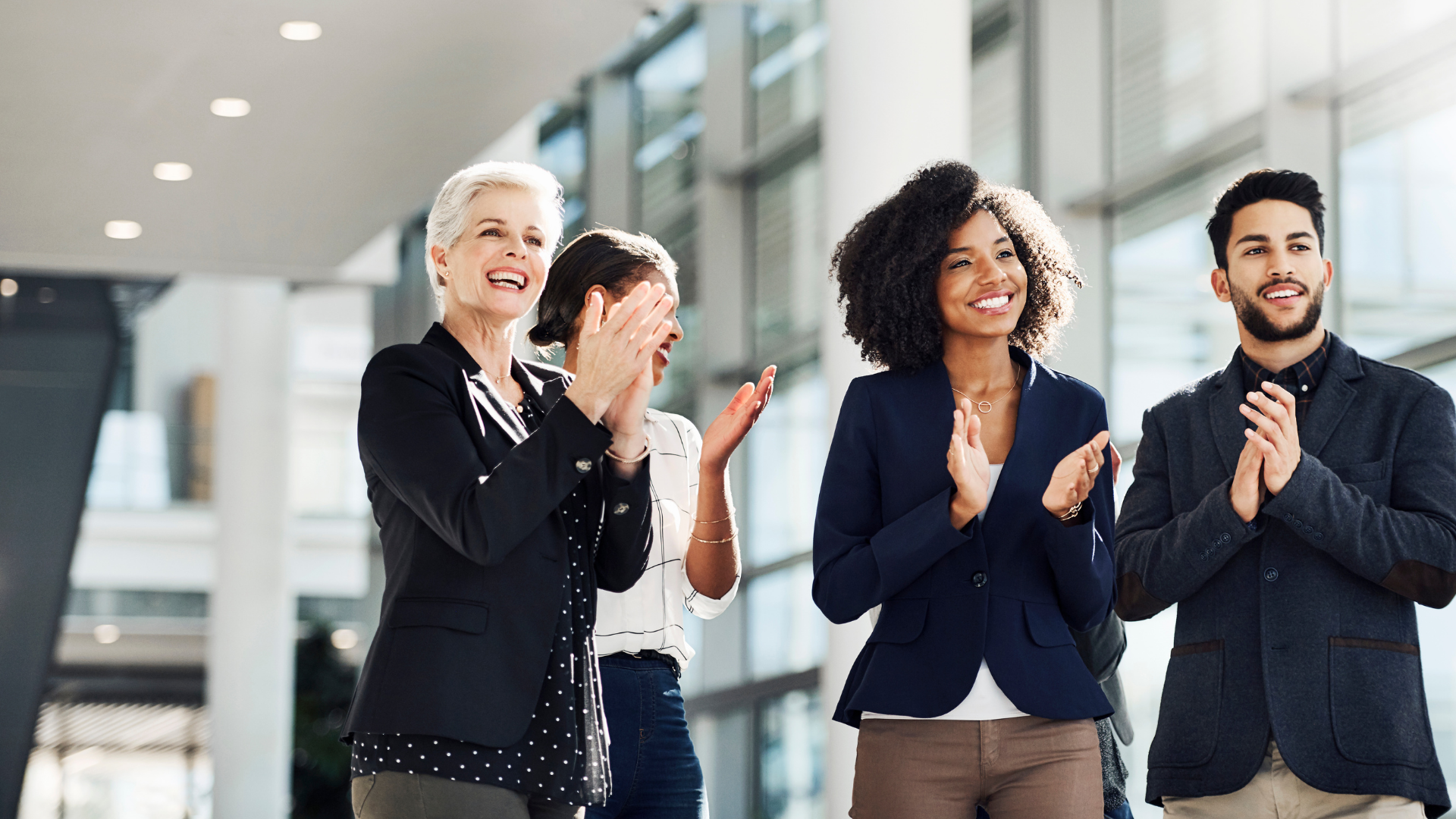 Four team members standing up applauding.