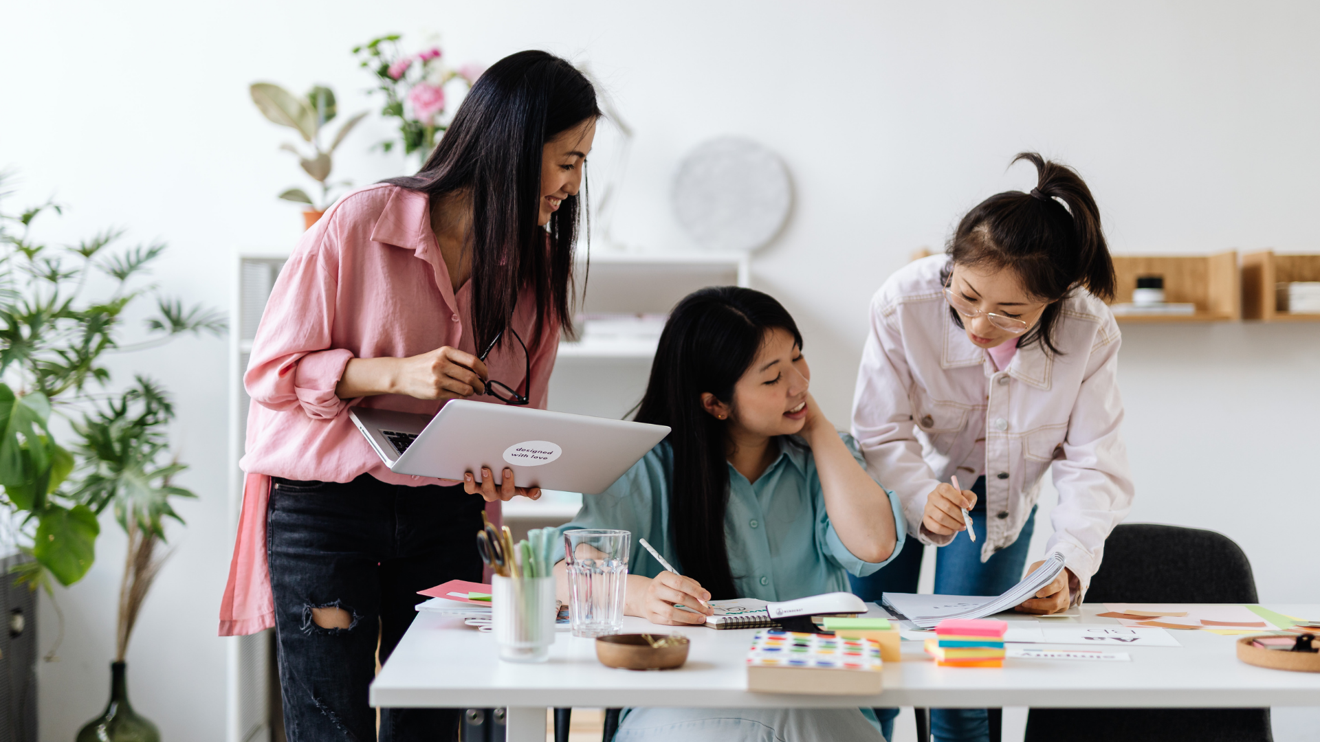 women employees working together around a desk