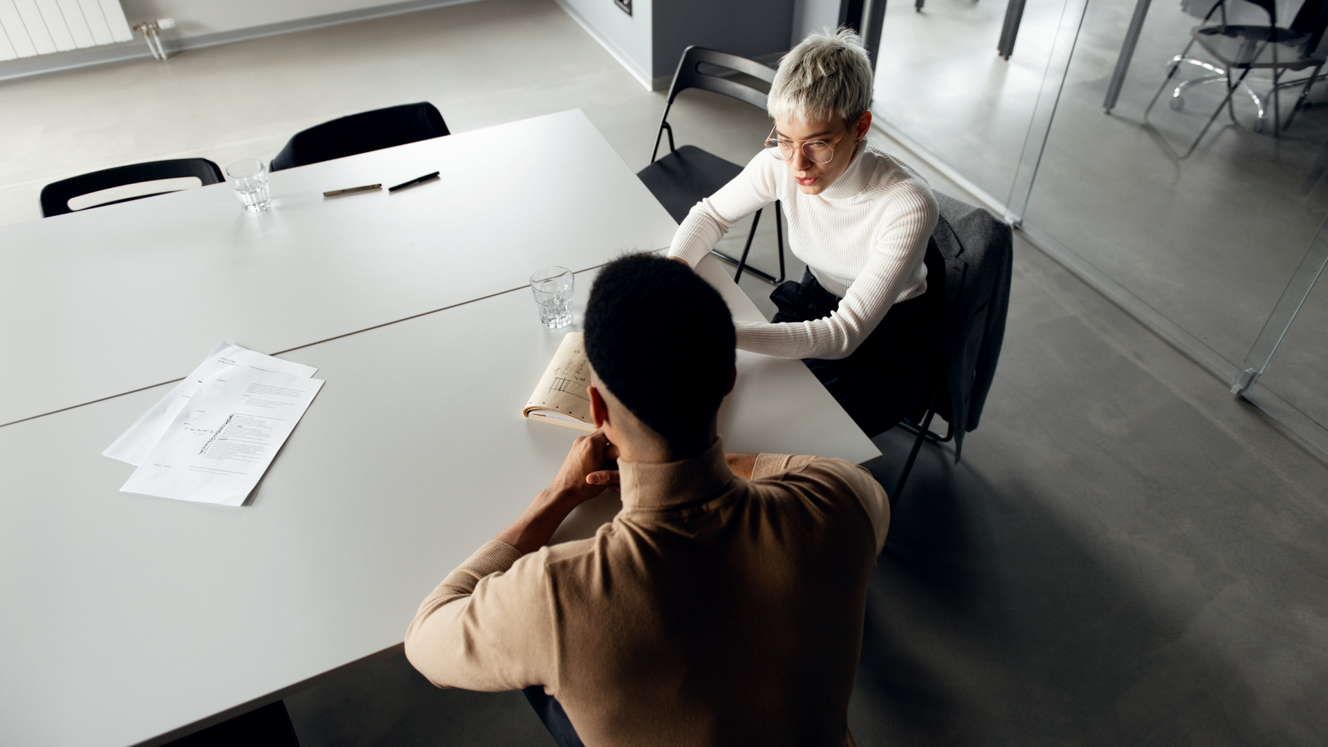 Two employees sitting together around a table working on a project together