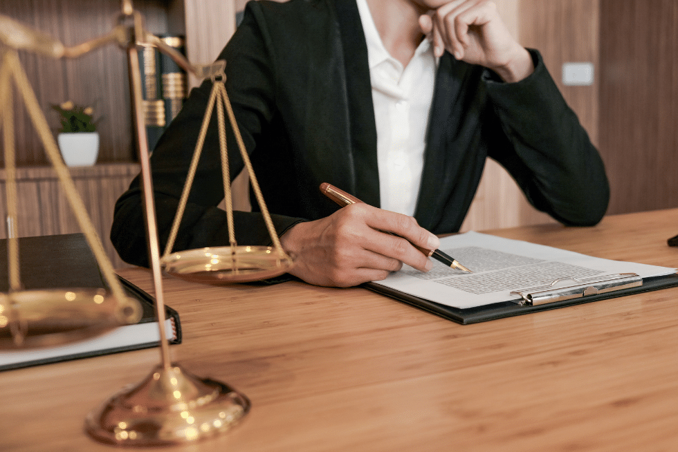 legal professional reviewing contract with a legal balance set ahead of him